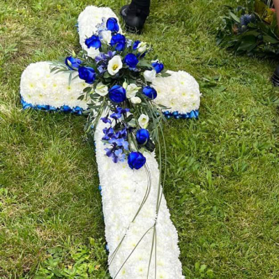 Cross of Serenity - A solemn cross arrangement with white flowers and blue accents, providing a respectful tribute for memorials. colours can be changed to your choice